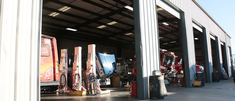 picture of mccray facility. Mechanic shop area with a blue truck being repair and a fire truck being repaired.