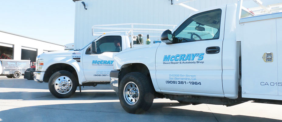 close up of a ford and chevy unitily trucks with McCray logo on side driverside doors.
