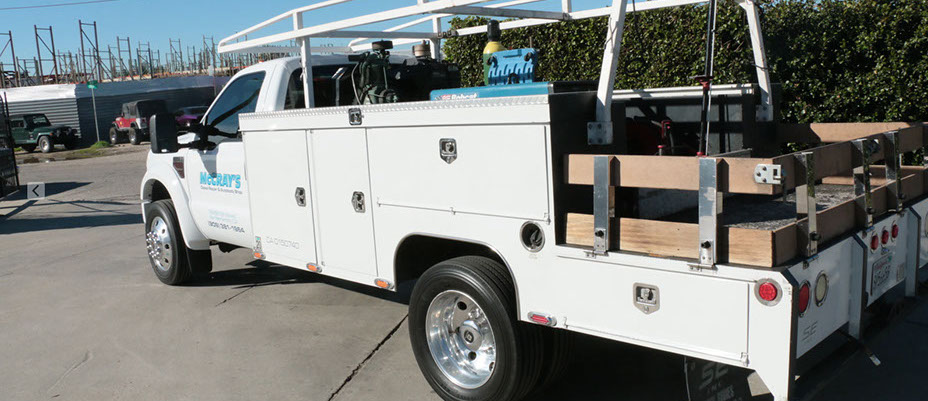 rear angle shot of a white McCray ford truck 